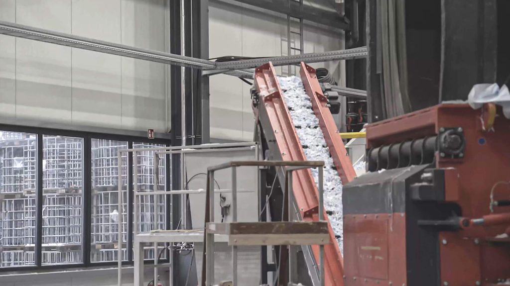 The shredded material is discharged with a conveyor belt