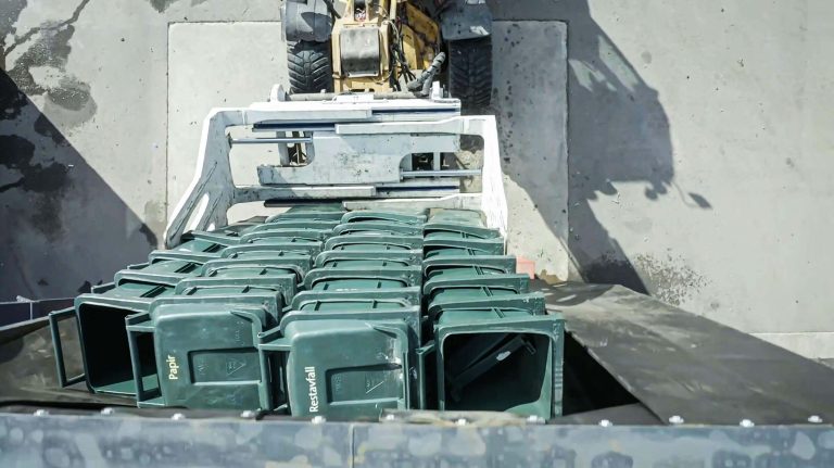 Befüllung des Shredders mit gestapelten leeren Abfalltonnen