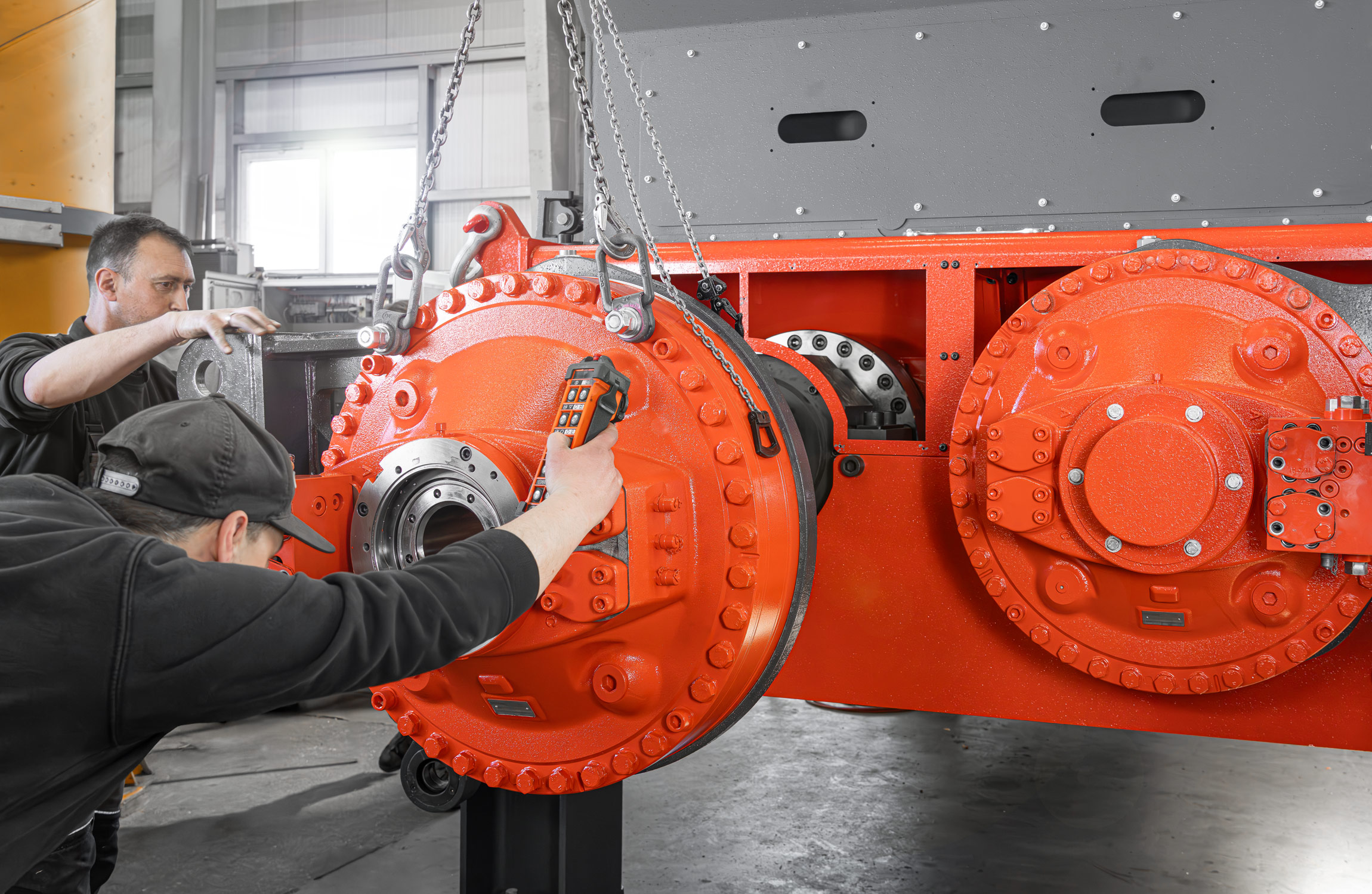 Montage des Hägglunds Hydraulikmotors beim M8 Shredder von zwei Personen