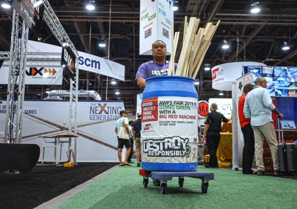 Freeman worker collects wood waste on the tradeshow floor