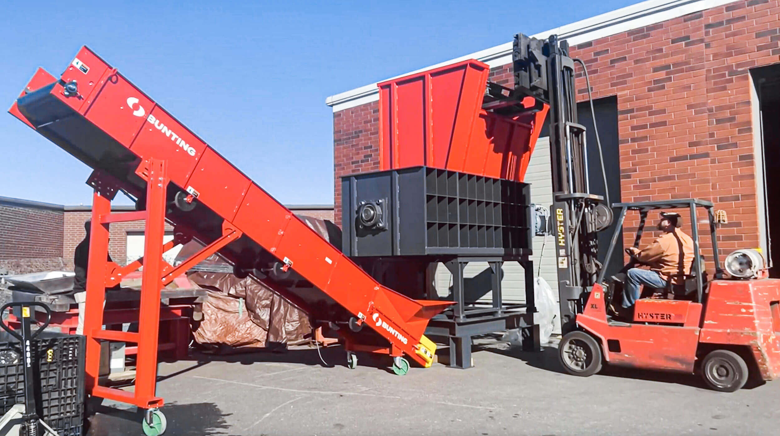 Ein Mitarbeiter beschickt einen Zerkleinerer per Gabelstapler