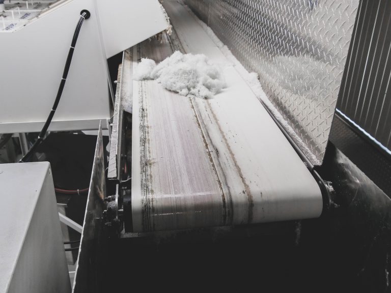 Ein Fließband befördert das geschredderte Material zum nächsten Verarbeitungsschritt