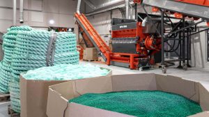 shredded, granulated and extruded fishing ropes in front of a weima shredder