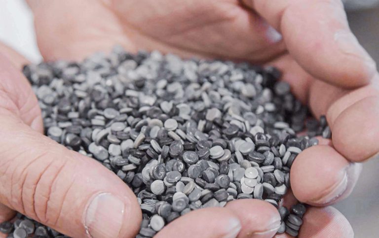 hands with regranulate from recycling of plastic film