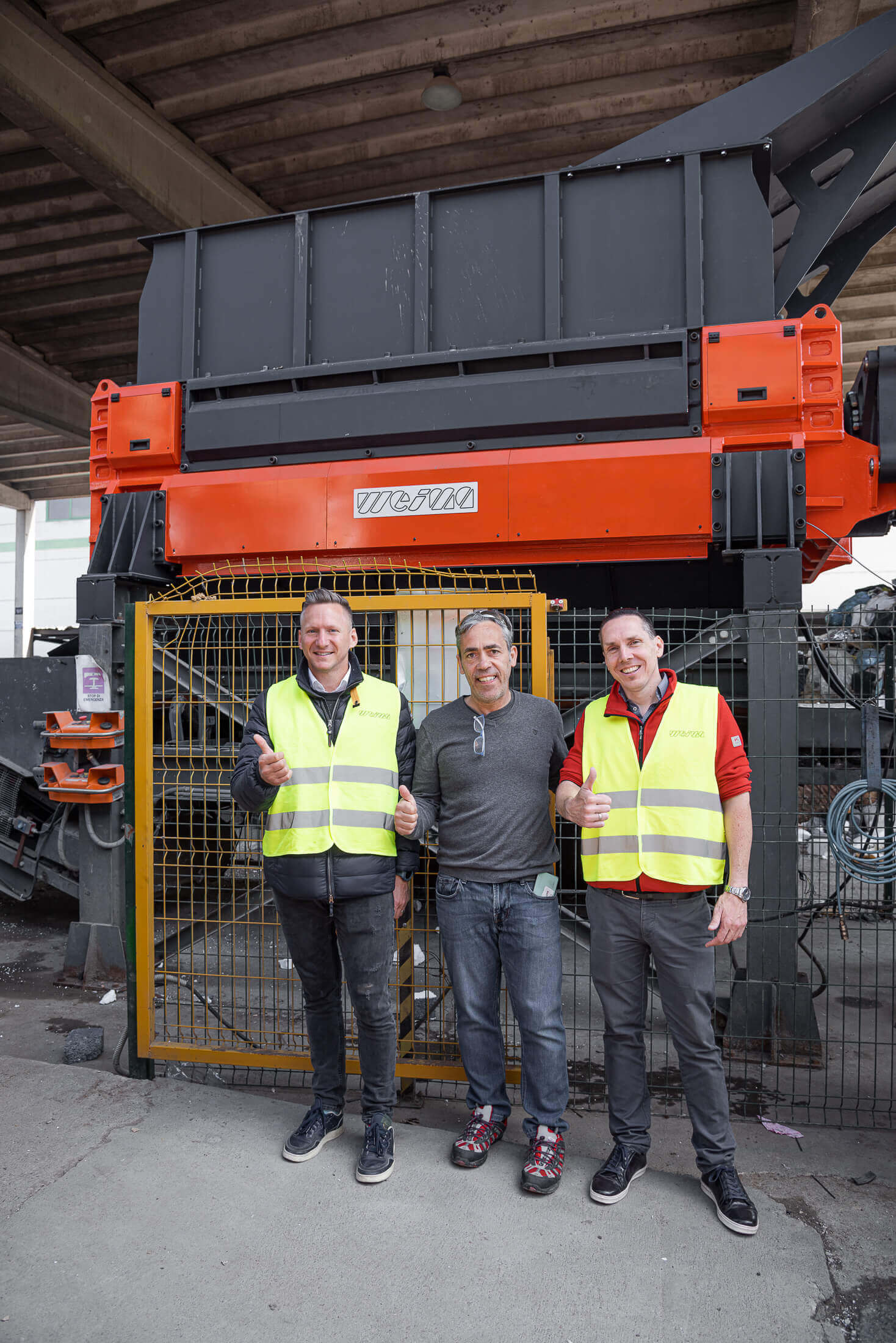 Drei Personen mit Warnweste vor einem WEIMA Shredder