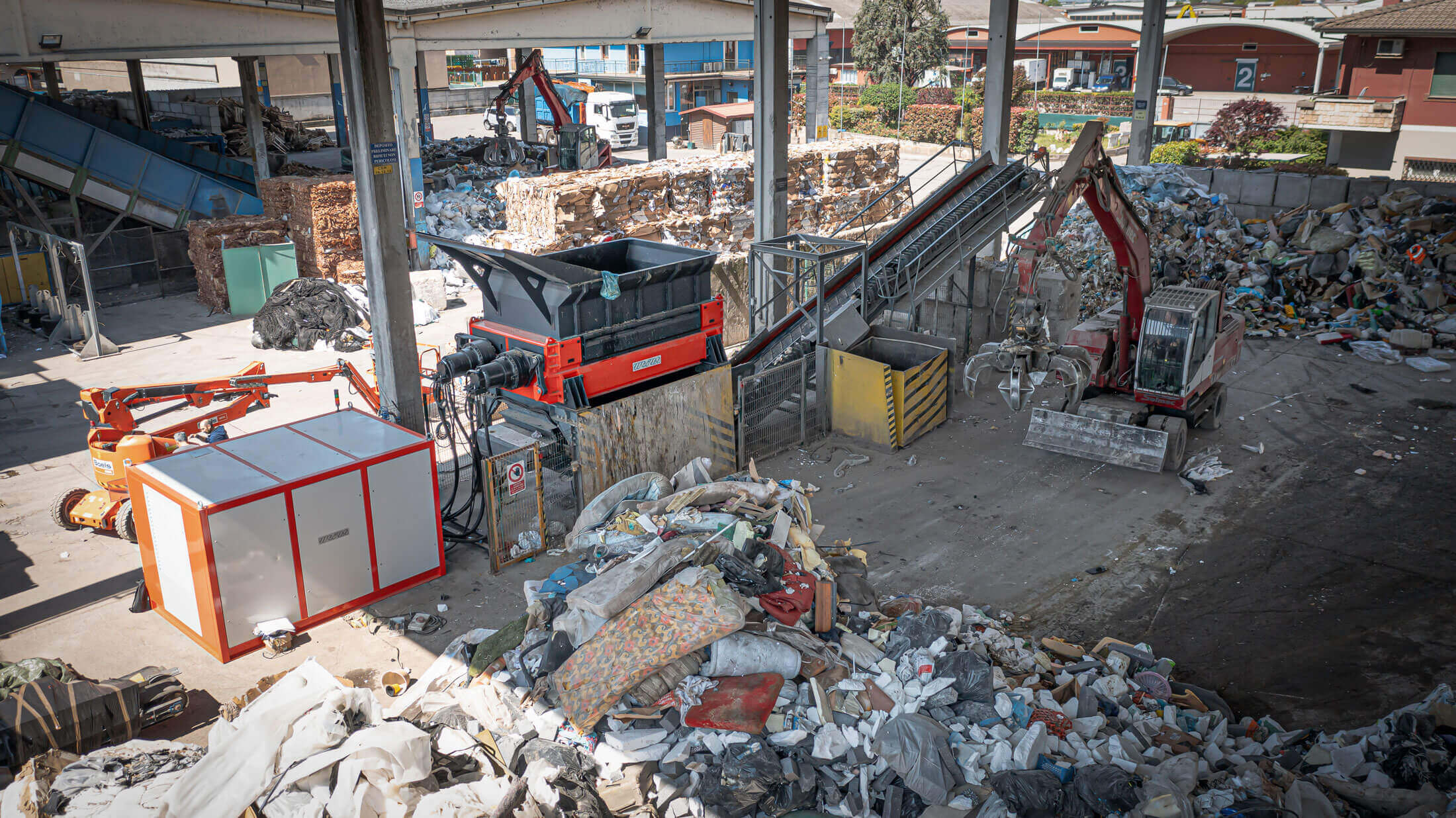 weima two-shaft shredder mit hydraulikantrieb, umgeben von müll für die zerkleinerung