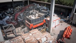 twin-shaft shredder by weima surrounded by mountains of waste
