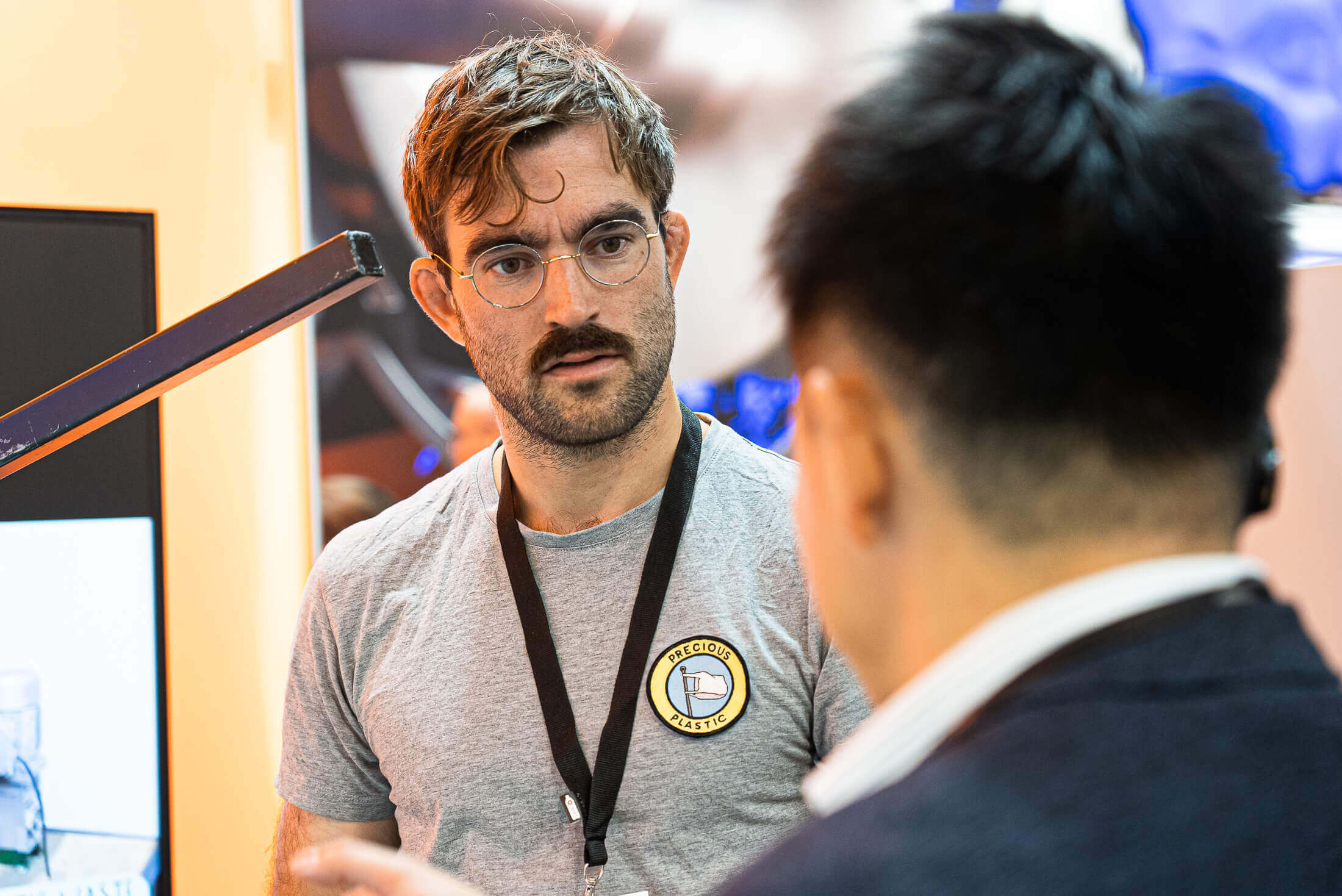 Precious Plastic employee talks to a visitor at K 2022 fair