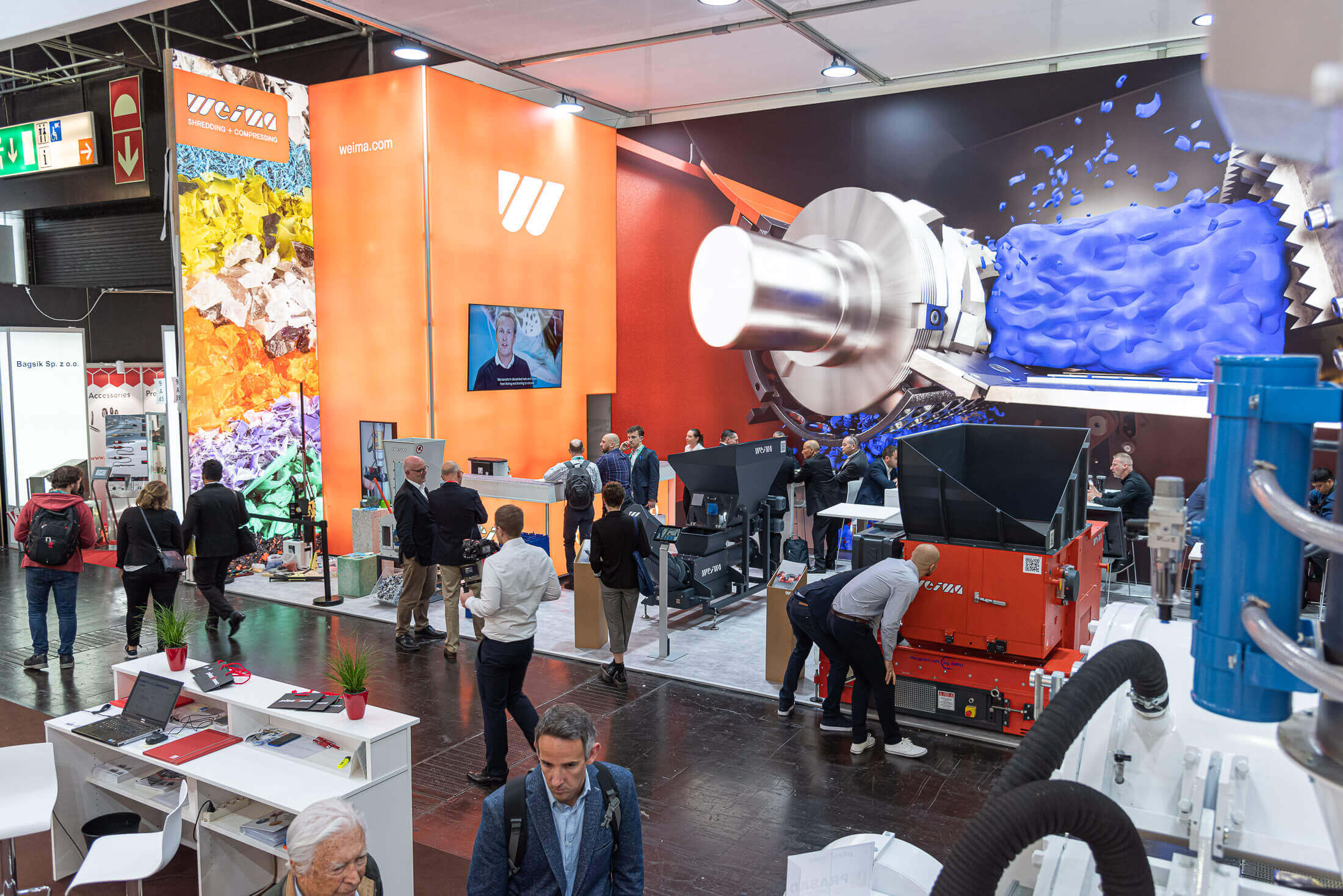 K trade show booth with visitors and weima shredders