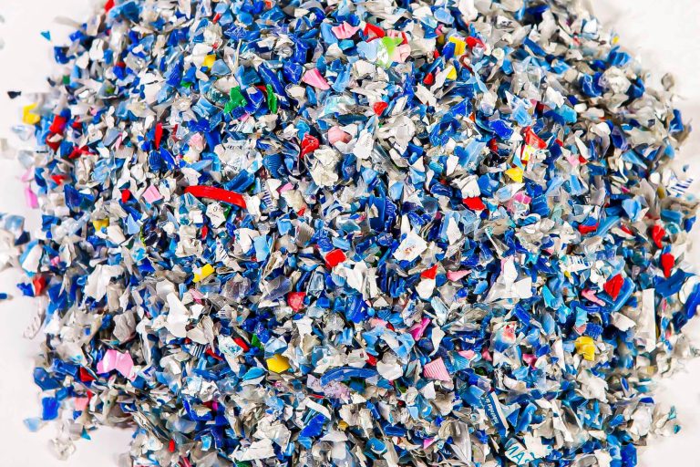 blue and white plastic flakes pile after being shredded