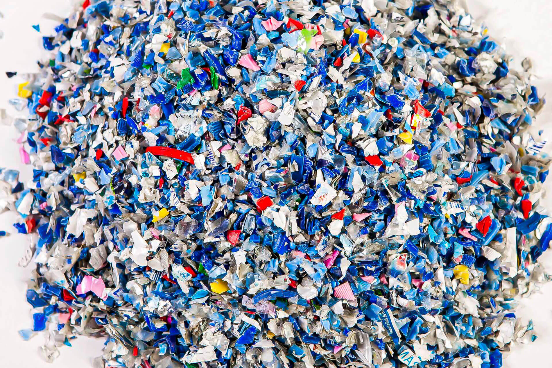 blue and white plastic flakes pile after being shredded