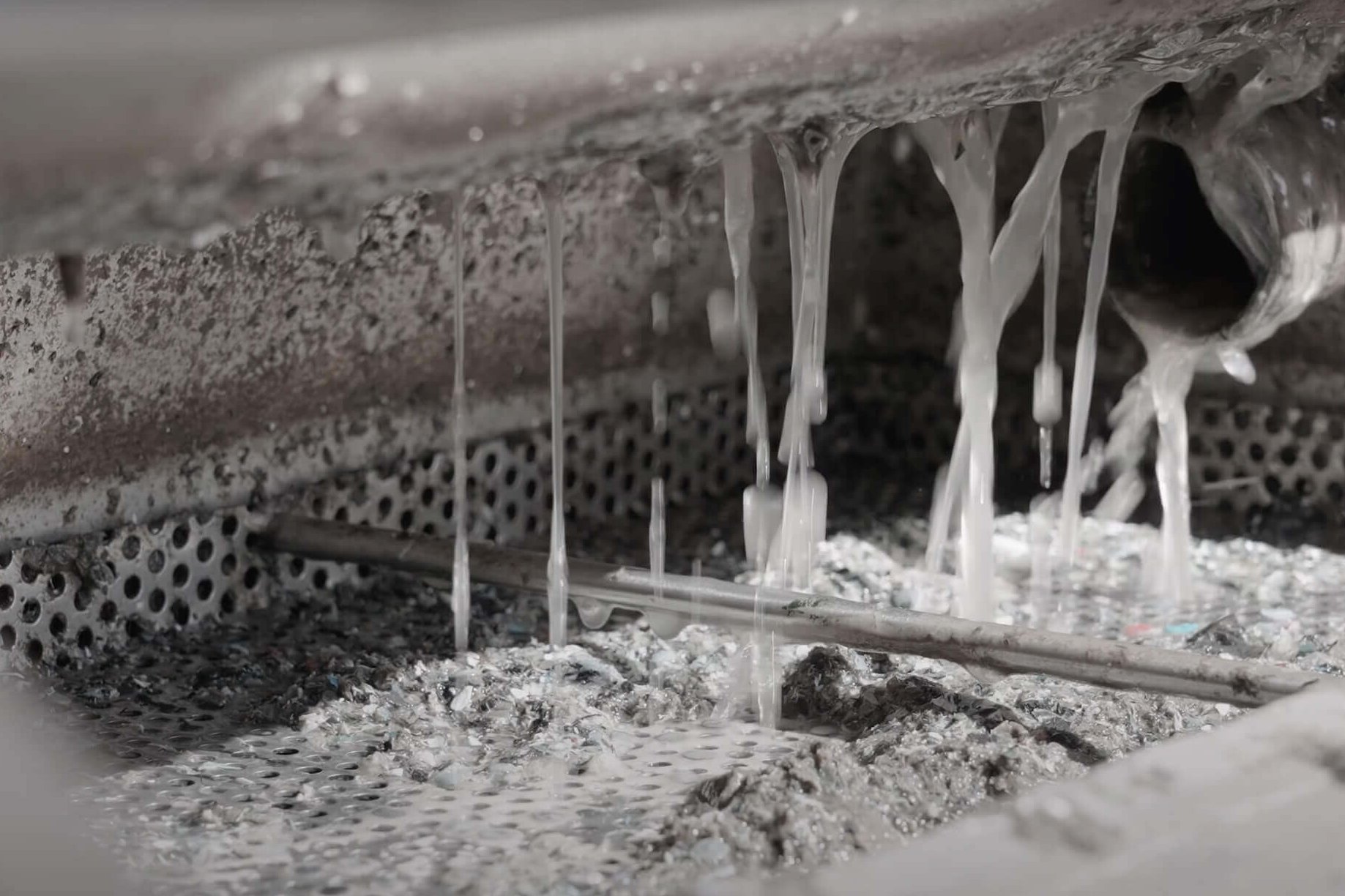water drains inside a metal collection bin