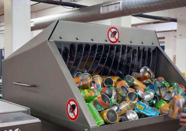 Die WEIMA E.200 Entwässerungspresse wird von Hand mit den beschädigen oder falsch abgefüllten Dosen gefüllt.