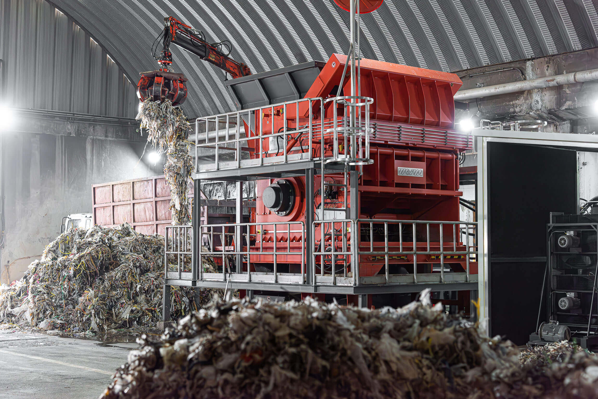 WEIMA PreCut 2500 shredder loaded with pulper waste via crane