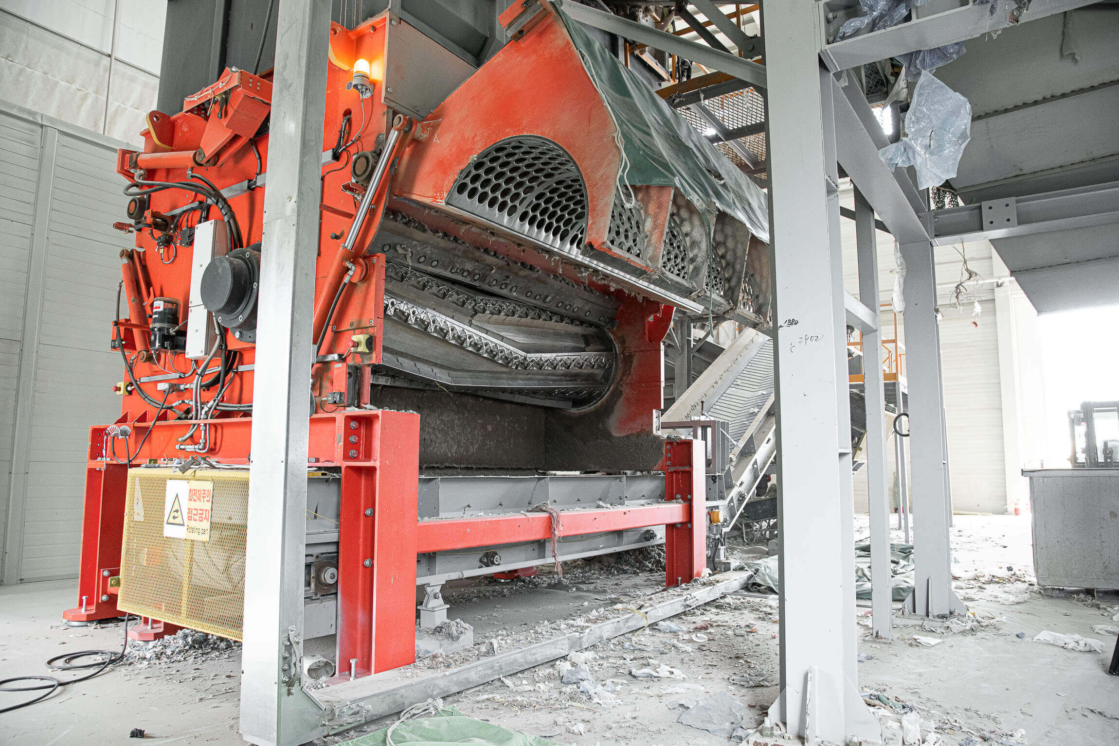 A WEIMA shredder with open screen basket and view into the interior in an industrial hall