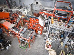 Luftansicht von einem orangenen Shredder der Siedlungsabfälle in einem Recyclingunternehmen in Südkorea zerkleinert
