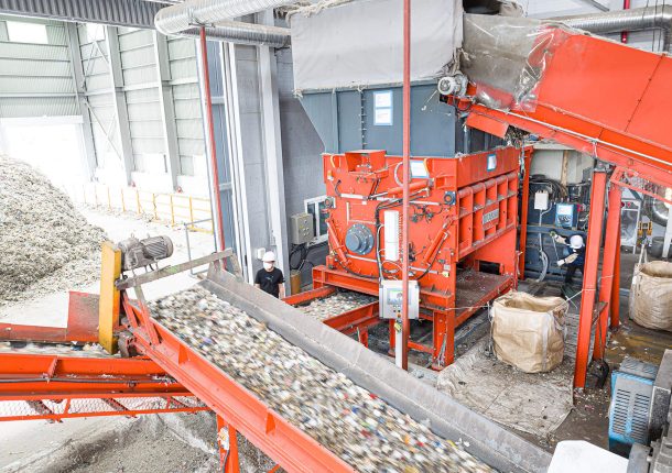 orangener Shredder der Siedlungsabfälle in einem Recyclingunternehmen in Südkorea zerkleinert