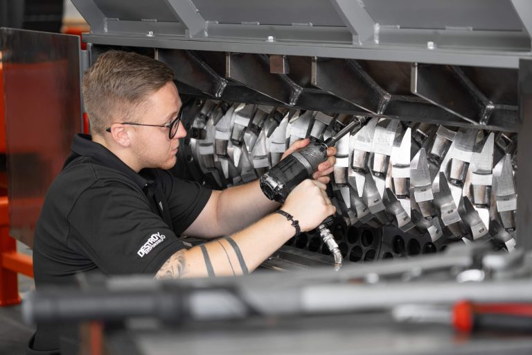 Ein WEIMA Mitarbeiter arbeitet mit einem Werkzeug am Rotor eines WEIMA Shredders