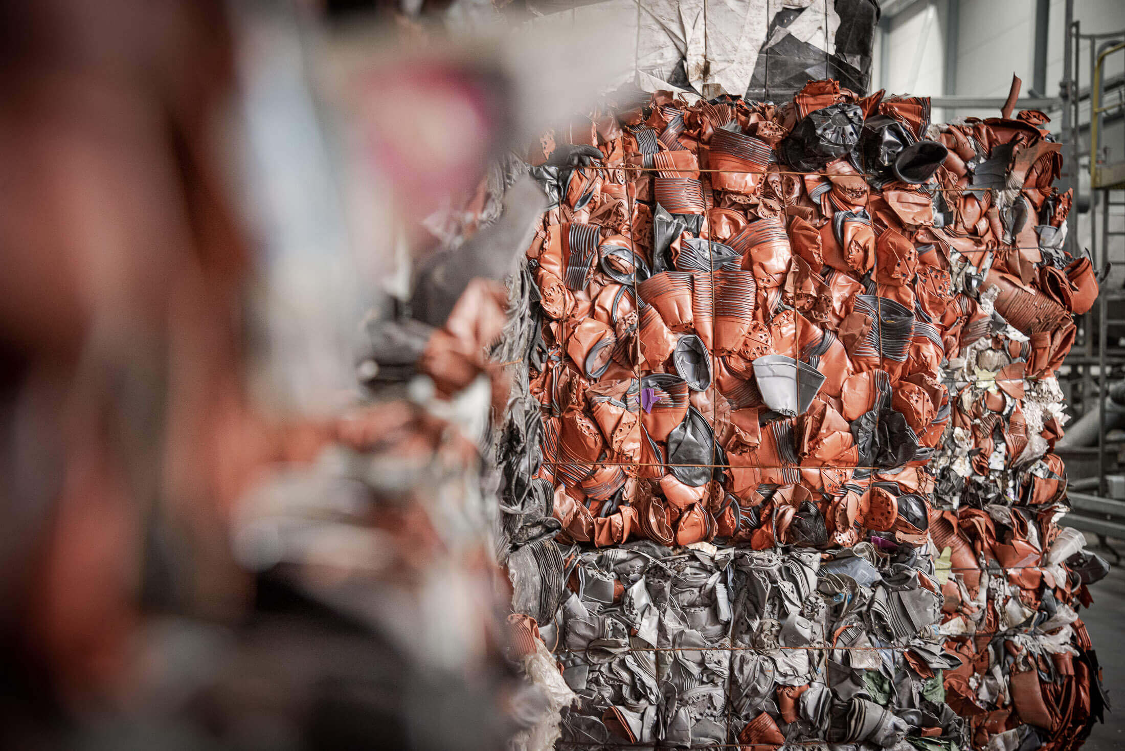 Bales of red and gray plastic flower pots before shredding with a WEIMA shredder