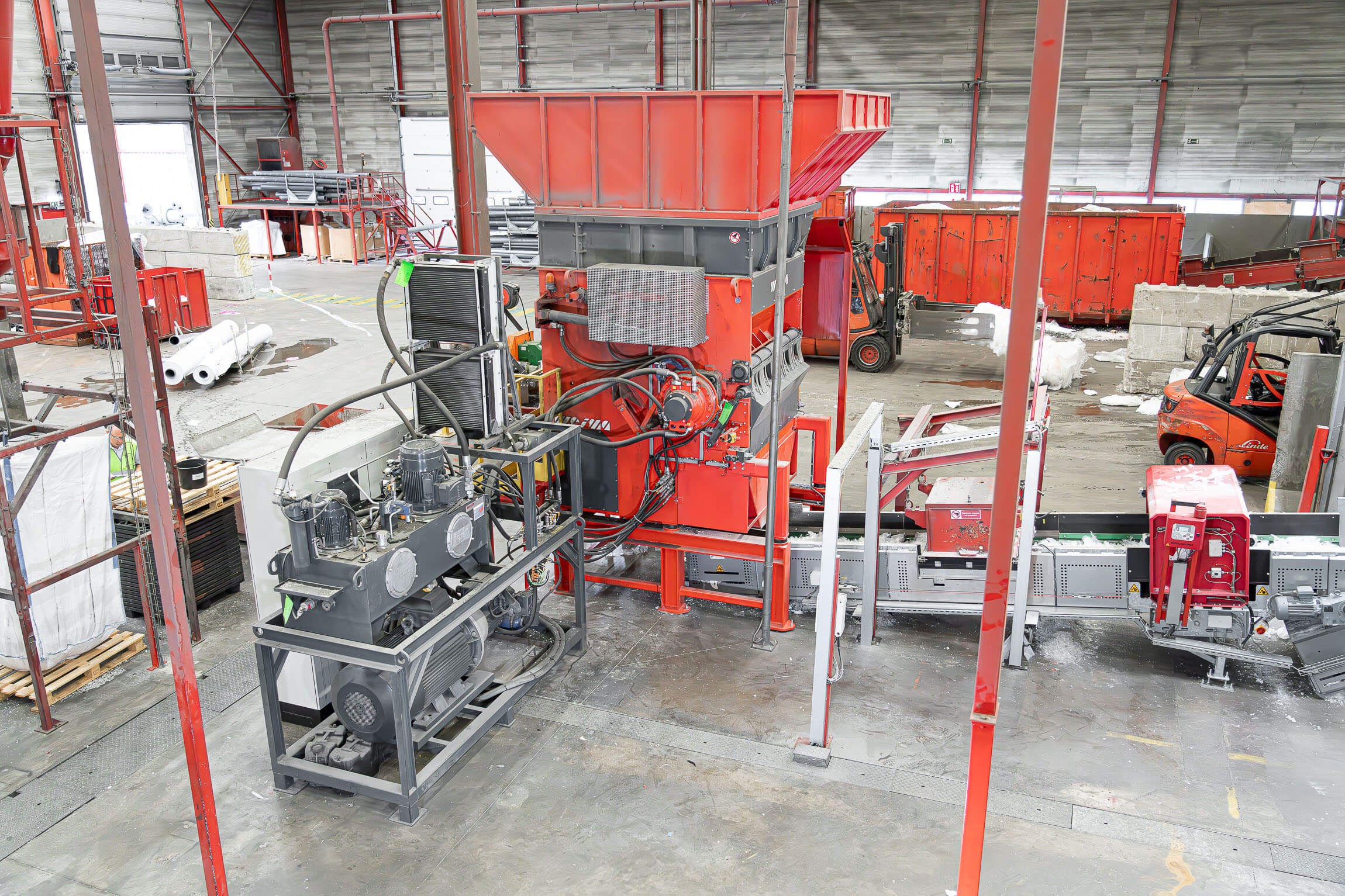 Ein orangefarbener WEIMA W5.18 Einwellen-Zerkleinerer zerkleinert LDPE Folie bei RKW in Hoogstraten, Belgien