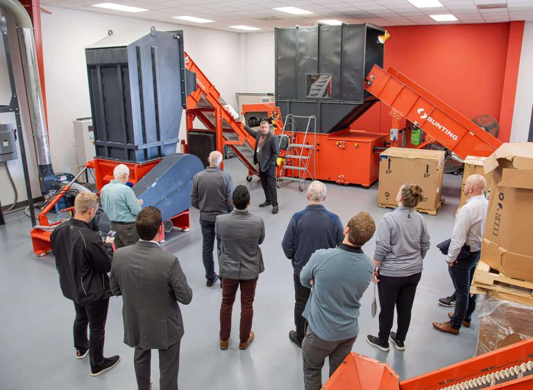 WEIMA CEO points at a conveyor between two WEIMA shredders.