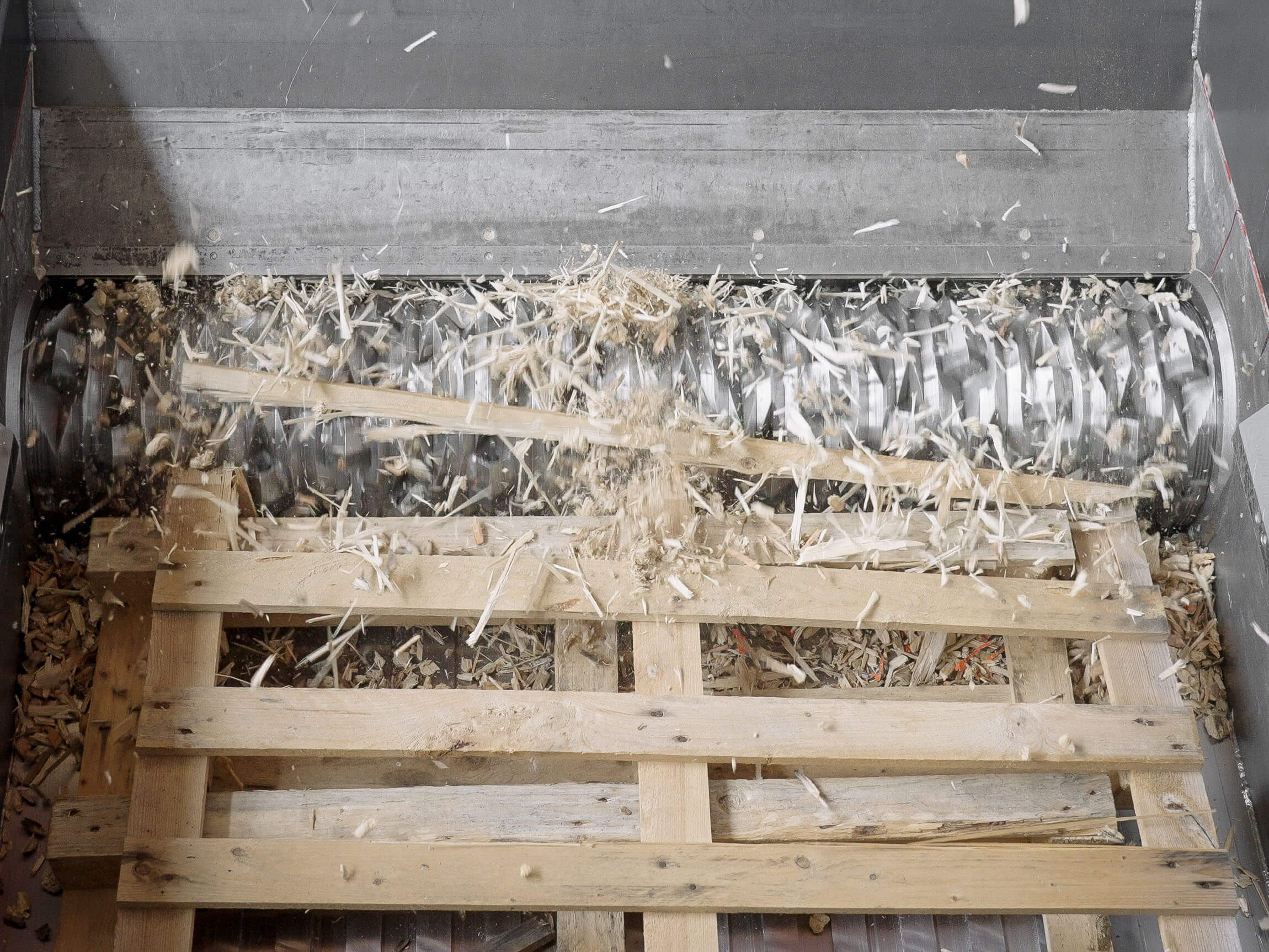Eine Palette wird im Shredder zerkleinert.