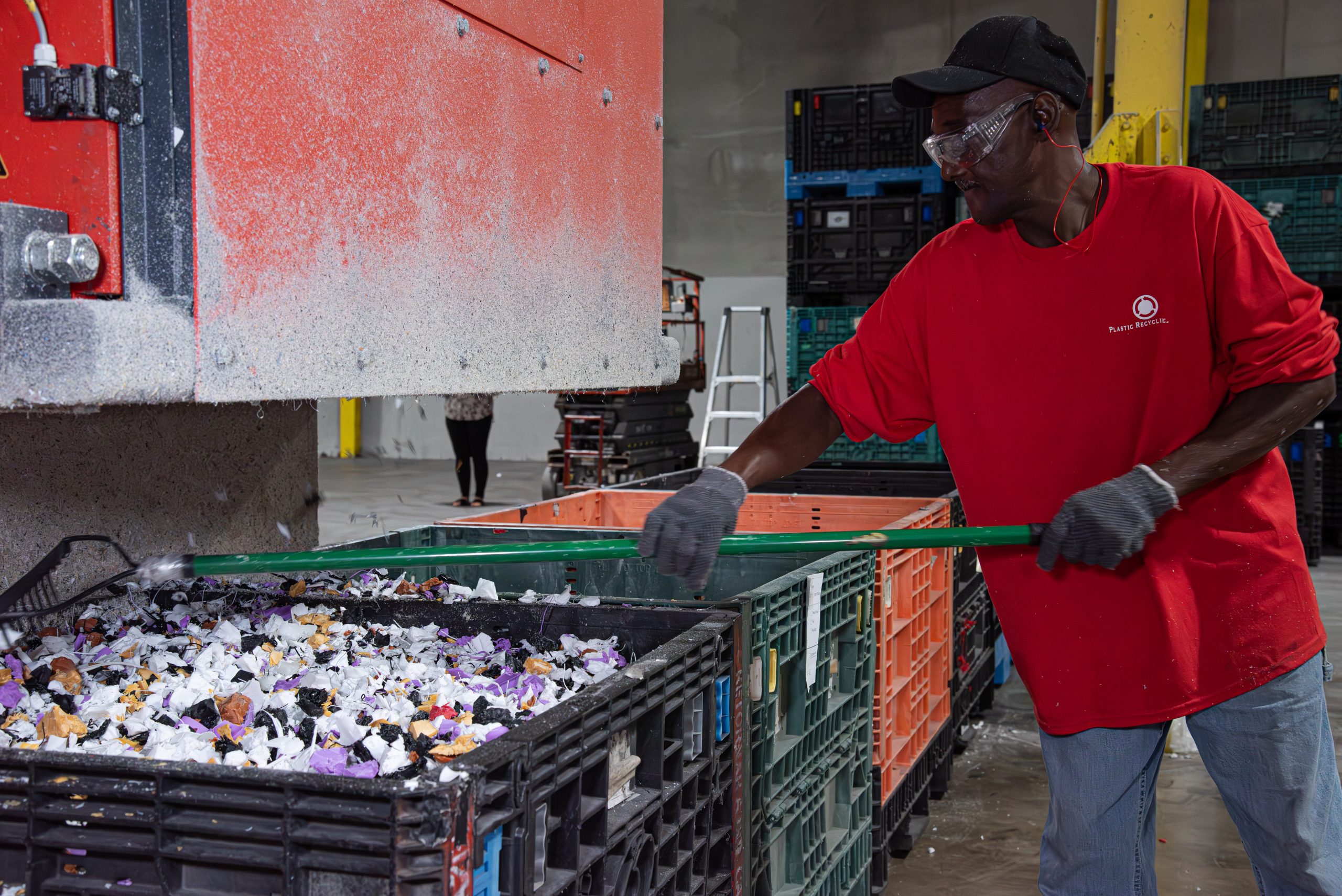 Ein Mitarbeiter überprüft und wiegt das zerkleinerte Material