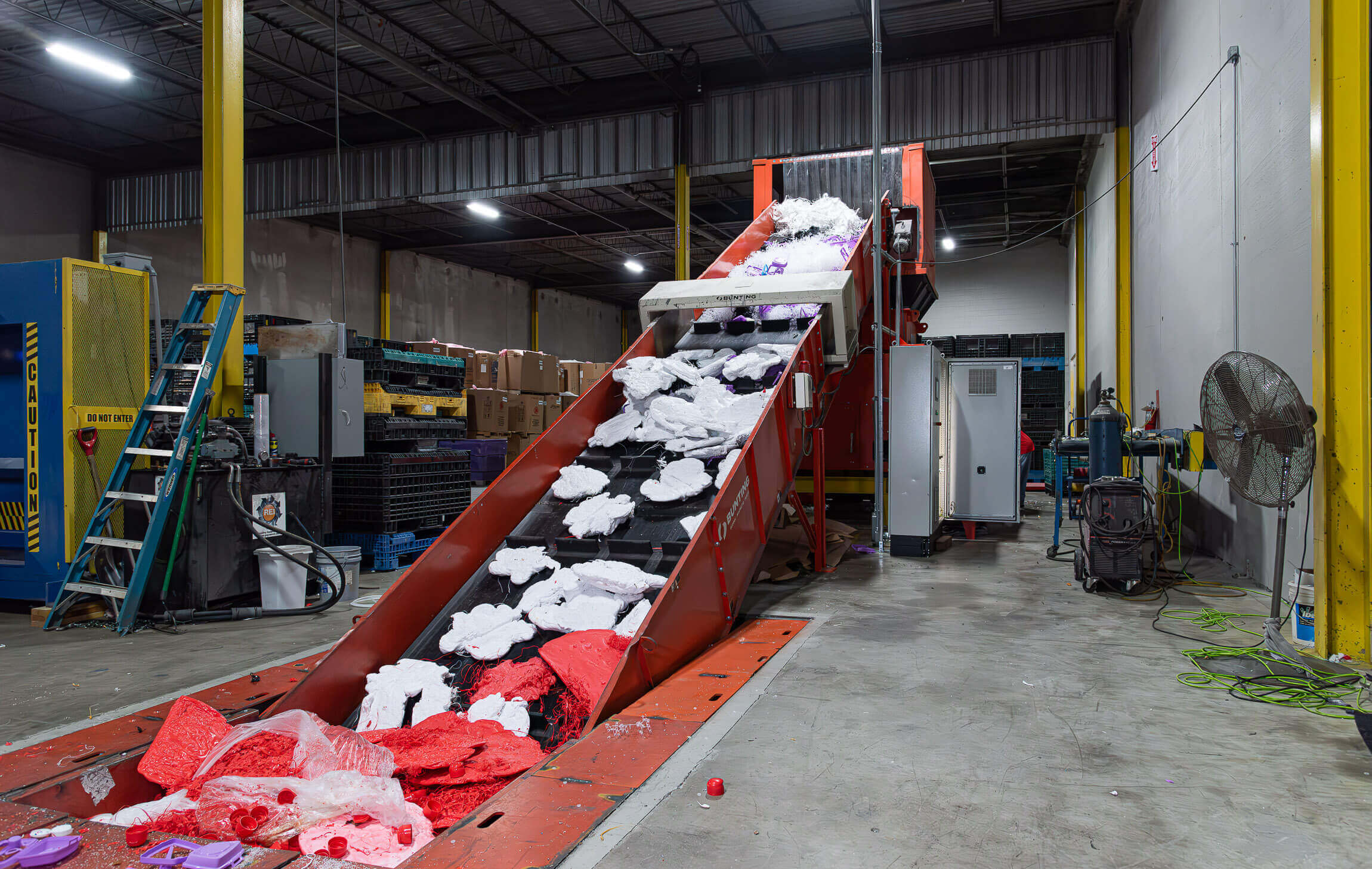 Ein langes Förderband transportiert Material zu einem Shredder.