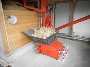 Mit Holzabfällen befüllter WEIMA WLK 1500 Shredder neben einem Spänebunker