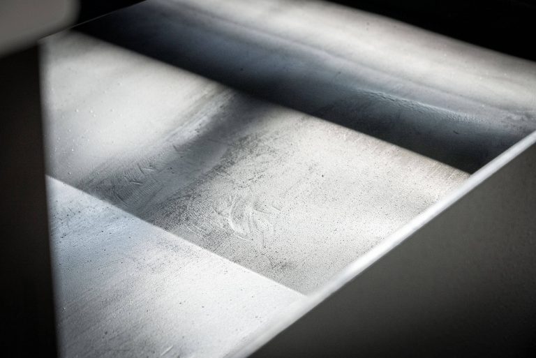 A gray collecting tray under a briquetting press