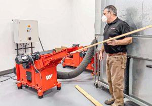 WEIMA Biber Zerkleinerer zerkleinert Holzleisten, daneben ein Mann, der die Maschine befüllt