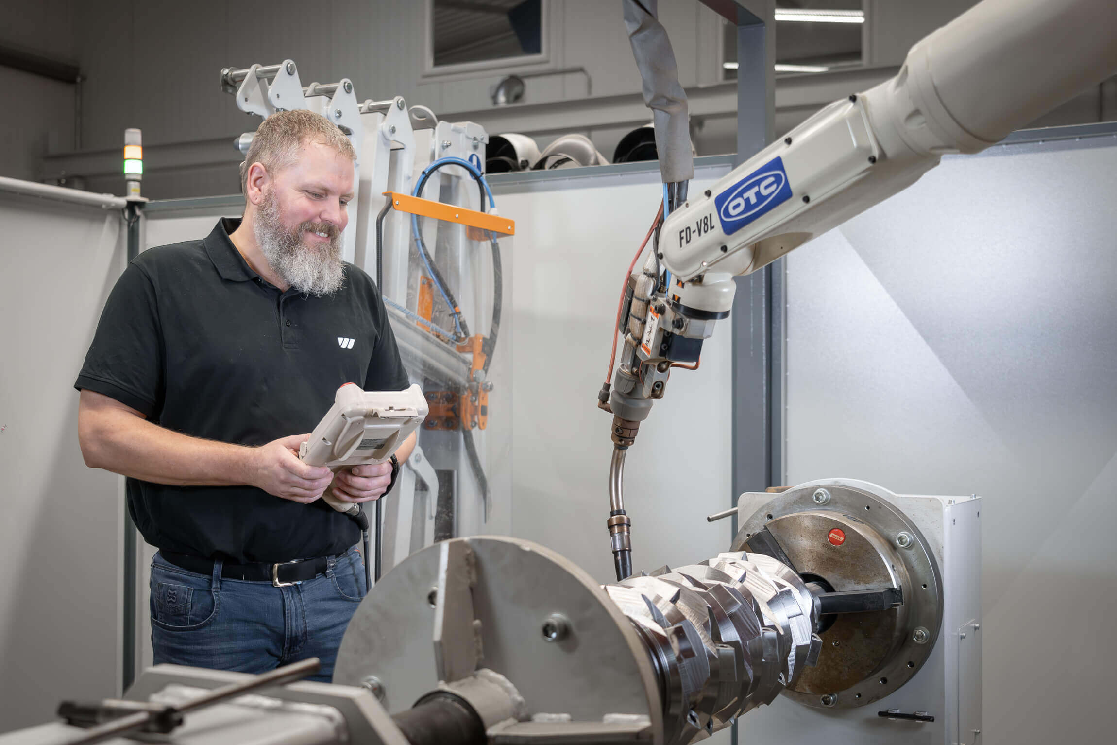 WEIMA Mitarbeiter programmiert einen Schweißrobotor zum Schweißen eines Rotors