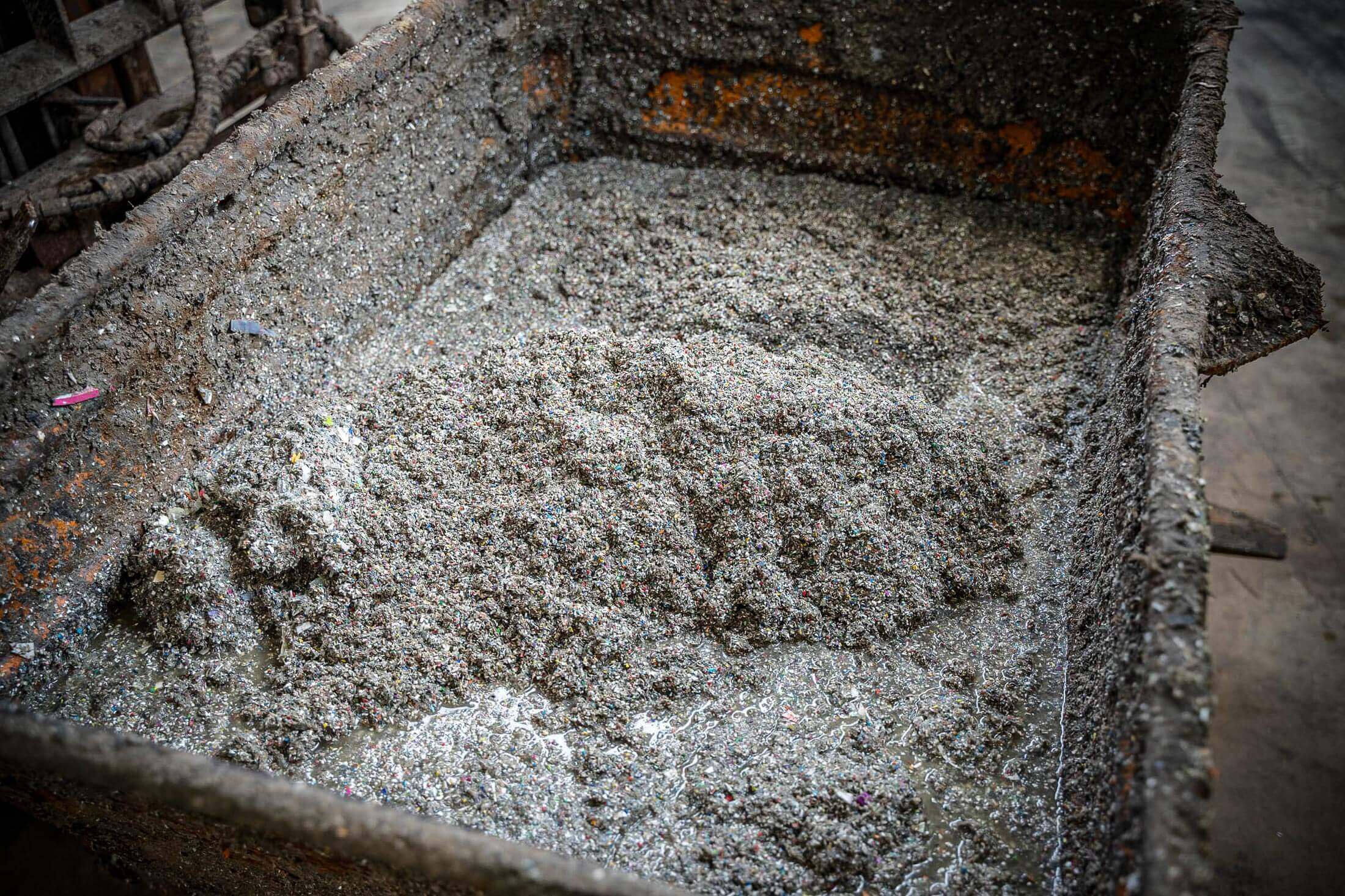 Kunststofffeinanteile vor der Entwässerung in einer Metallwanne