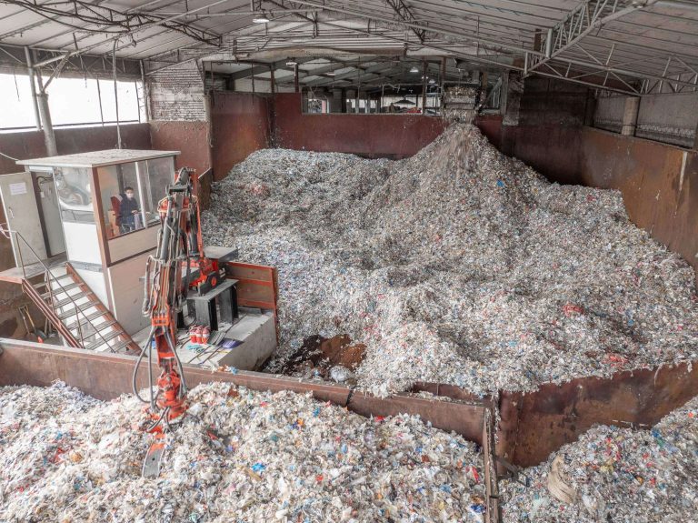 View from above into the bunker with shredded material, a crane transports the material further.