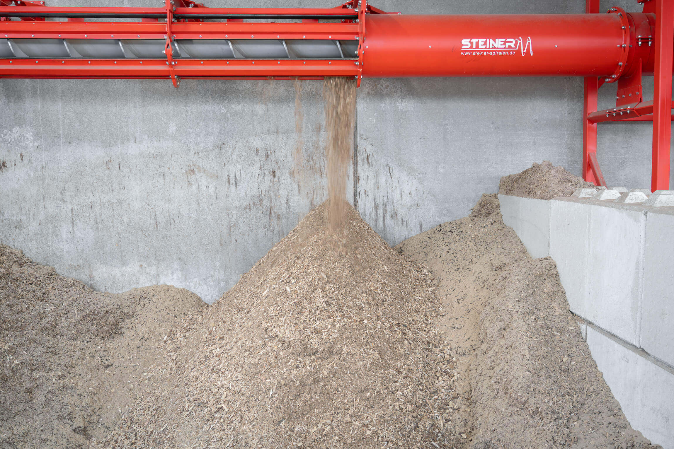 Aus groß wird klein: Hackschnitzel werden mit der Steiner-Förderschnecke in den Bunker transportiert.