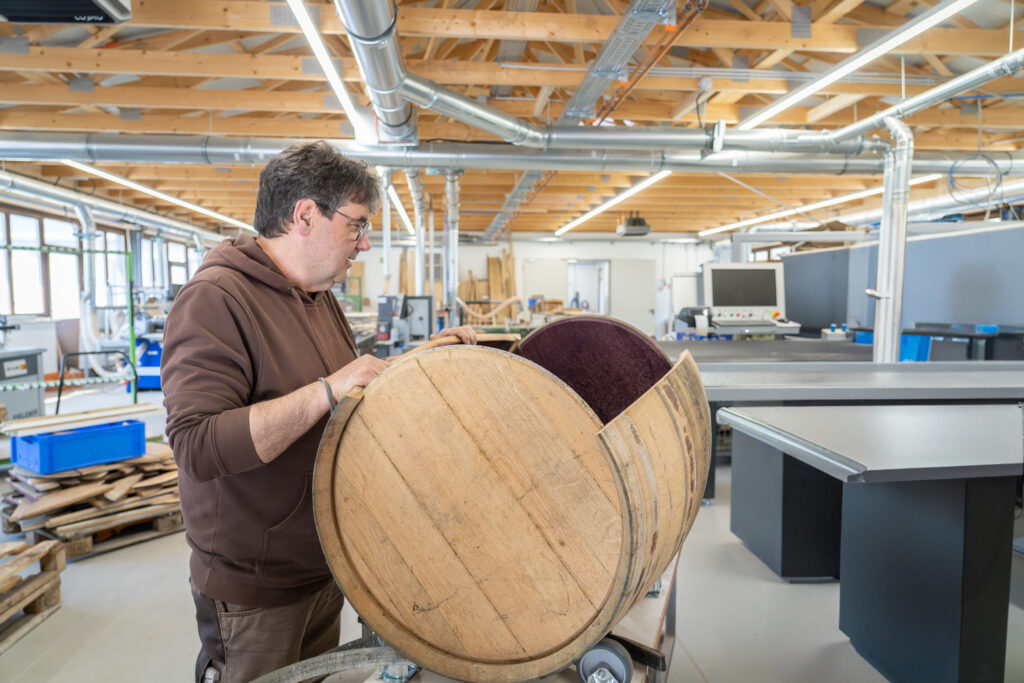 The carpenter dismantles the barrique barrel into its individual parts.